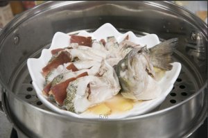 將鱸魚成花狀擺好，將火腿切片放入各縫隙中，放入鍋中隔水蒸12分鐘拿出，撒上蔥花即可。