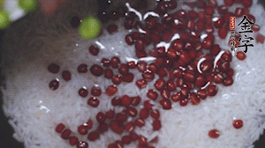 將炒好的食材和大米、紅豆一起放進(jìn)電飯鍋煮。