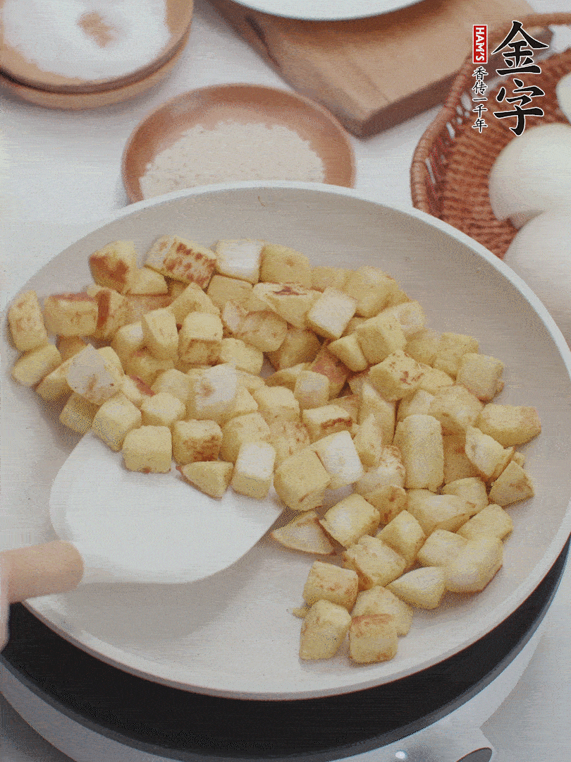 起鍋熱油，倒入饅頭丁，小火煎至蛋液凝固定型再翻面，饅頭丁部煎至金黃時盛起待用。