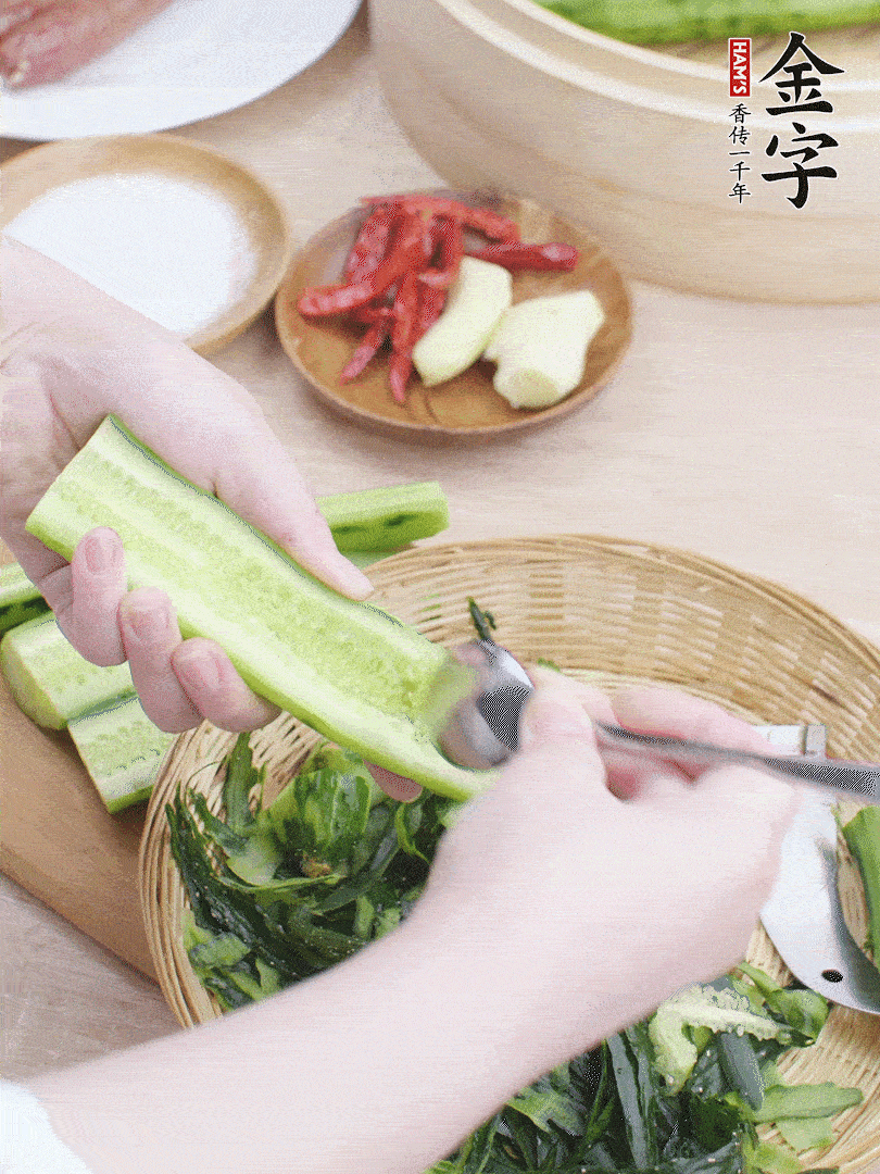 黃瓜削皮，對(duì)半切開(kāi)，勺子挖去內(nèi)瓤，斜刀切片。青蒜斜刀切段。