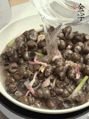 倒處理干凈的螺螄翻炒，加3勺料酒。加清水蓋過螺螄，中火蓋蓋煮5分鐘。