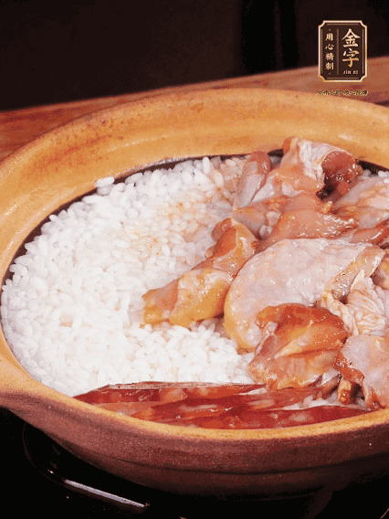 煮到椰子水微微收干轉(zhuǎn)小火，快速均勻鋪上雞肉、金字香腸