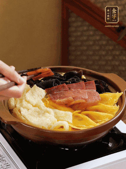 砂鍋底部鋪上娃娃菜，依次擺上肉皮、蛋餃、黑木耳、火腿